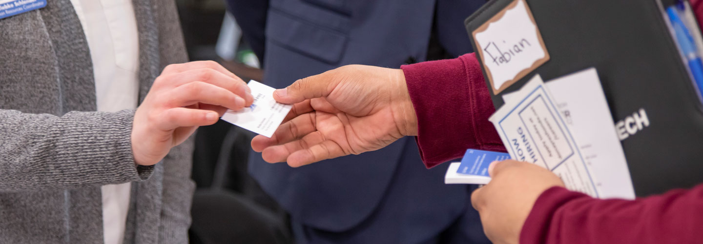 Student receiving a business card from a potential employer